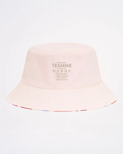 A soft blush pink cabana bucket hat featuring a subtle striped trim along the brim