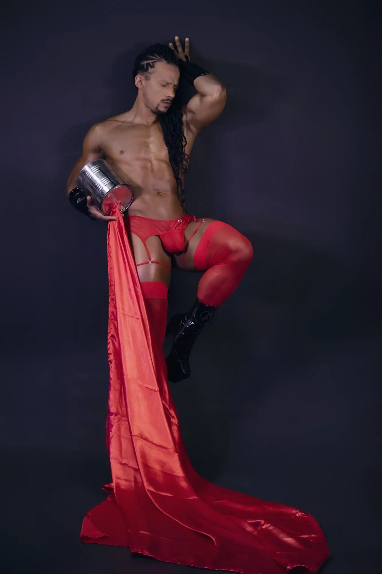 Shiny red satin fabric flowing from a mans leg showcasing candyman 99792 mesh garter thongs in red