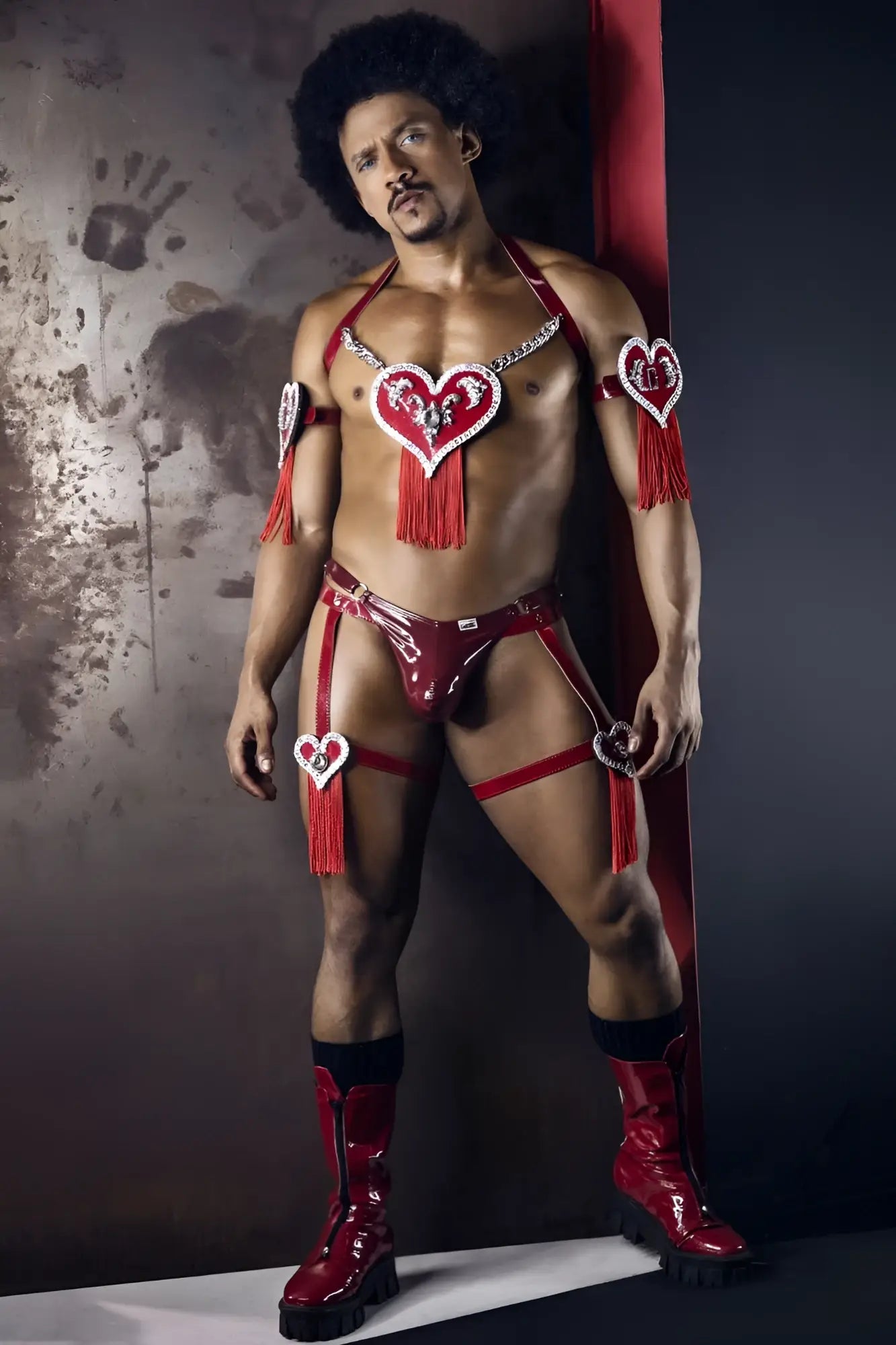 Red shiny latex dom thong with heart-shaped embellishments and tassels in gloss wine color from candyman 99819