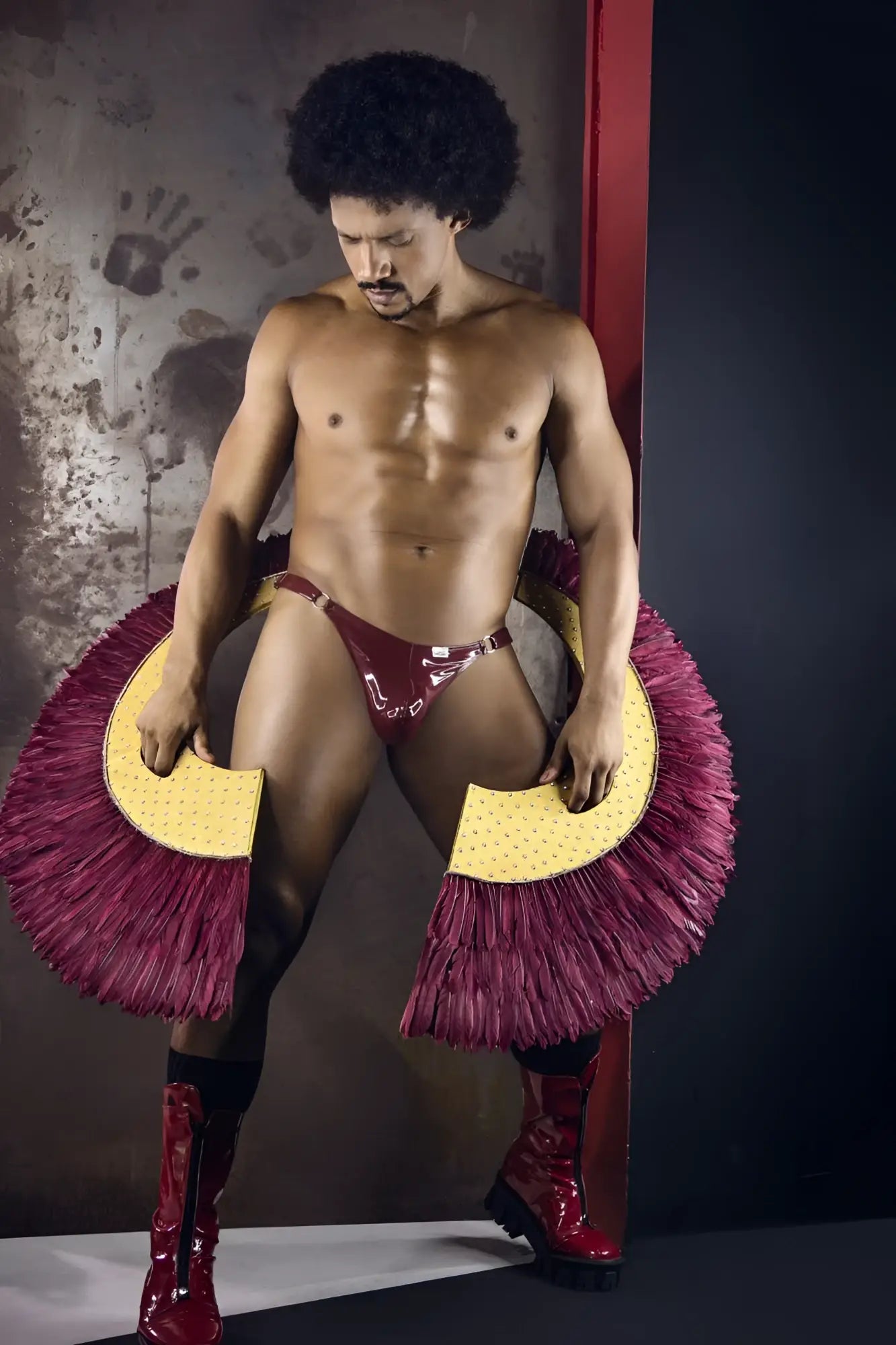 A shiny maroon latex thong with bold fringed magenta and yellow circular accessories on each side candyMan 99819 Dom Thongs color gloss wine