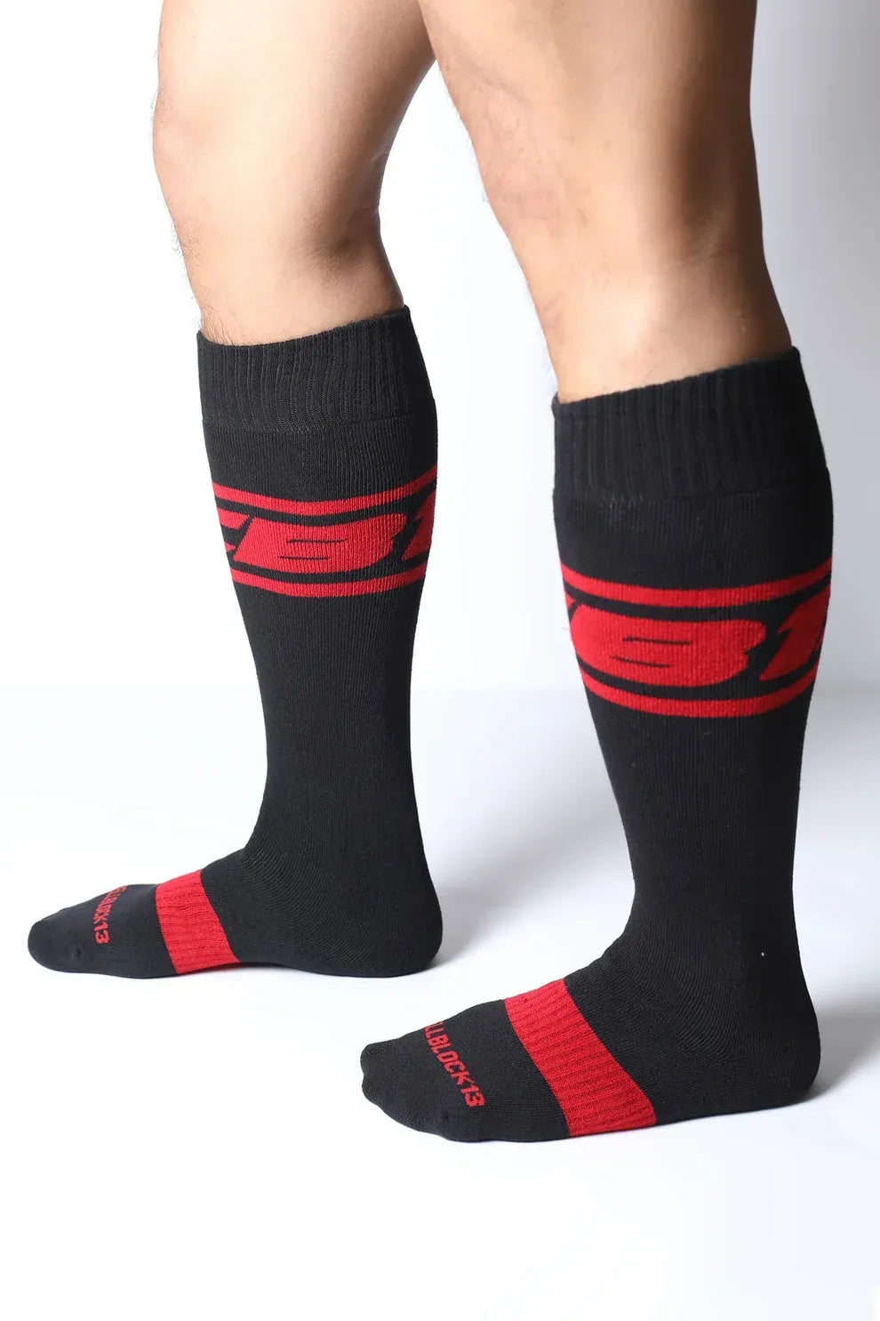Black knee-high socks with red accents featuring the CellBlock 13 logo worn by a model standing sideways