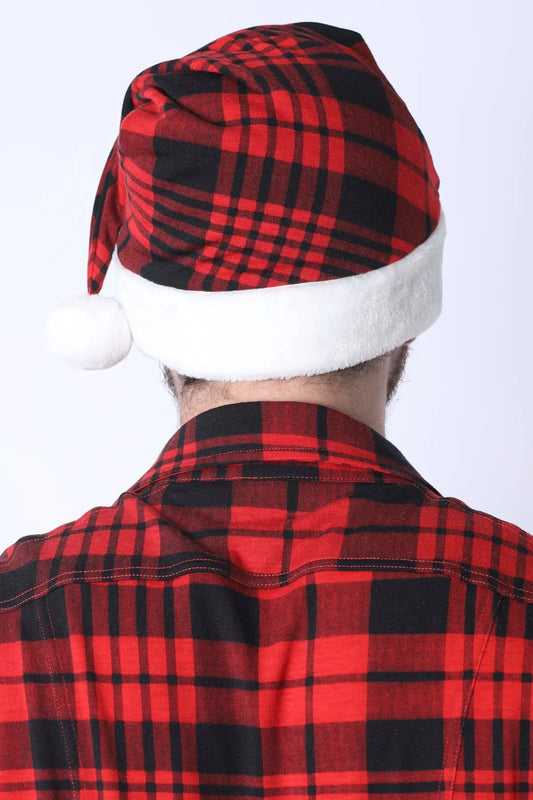 Red and black plaid Santa hat with white faux fur trim worn by a person in a plaid shirt by CellBlock 13