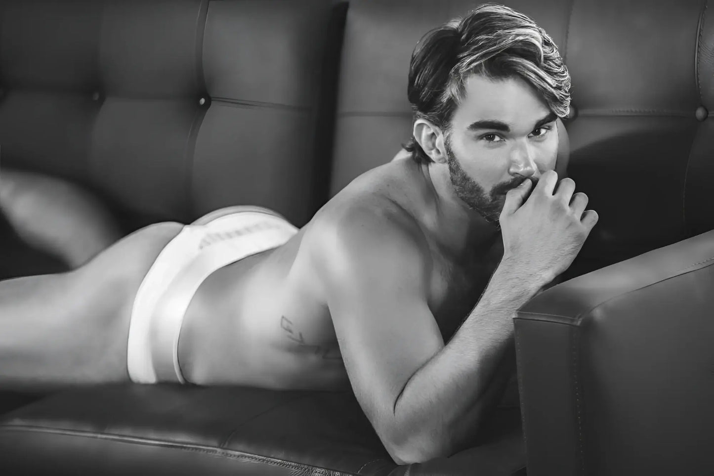 A man wearing white Clever 1034 Lucerna briefs lying on a couch showcasing the front fit and fabric detail
