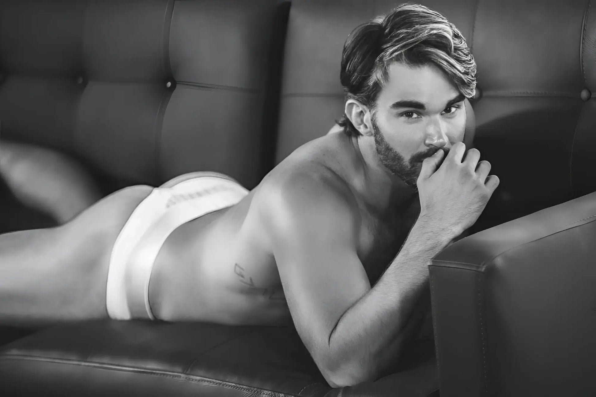 A man wearing white Clever 1034 Lucerna briefs lying on a couch showcasing the front fit and fabric detail