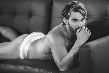 A man wearing white Clever 1034 Lucerna briefs lying on a couch showcasing the front fit and fabric detail