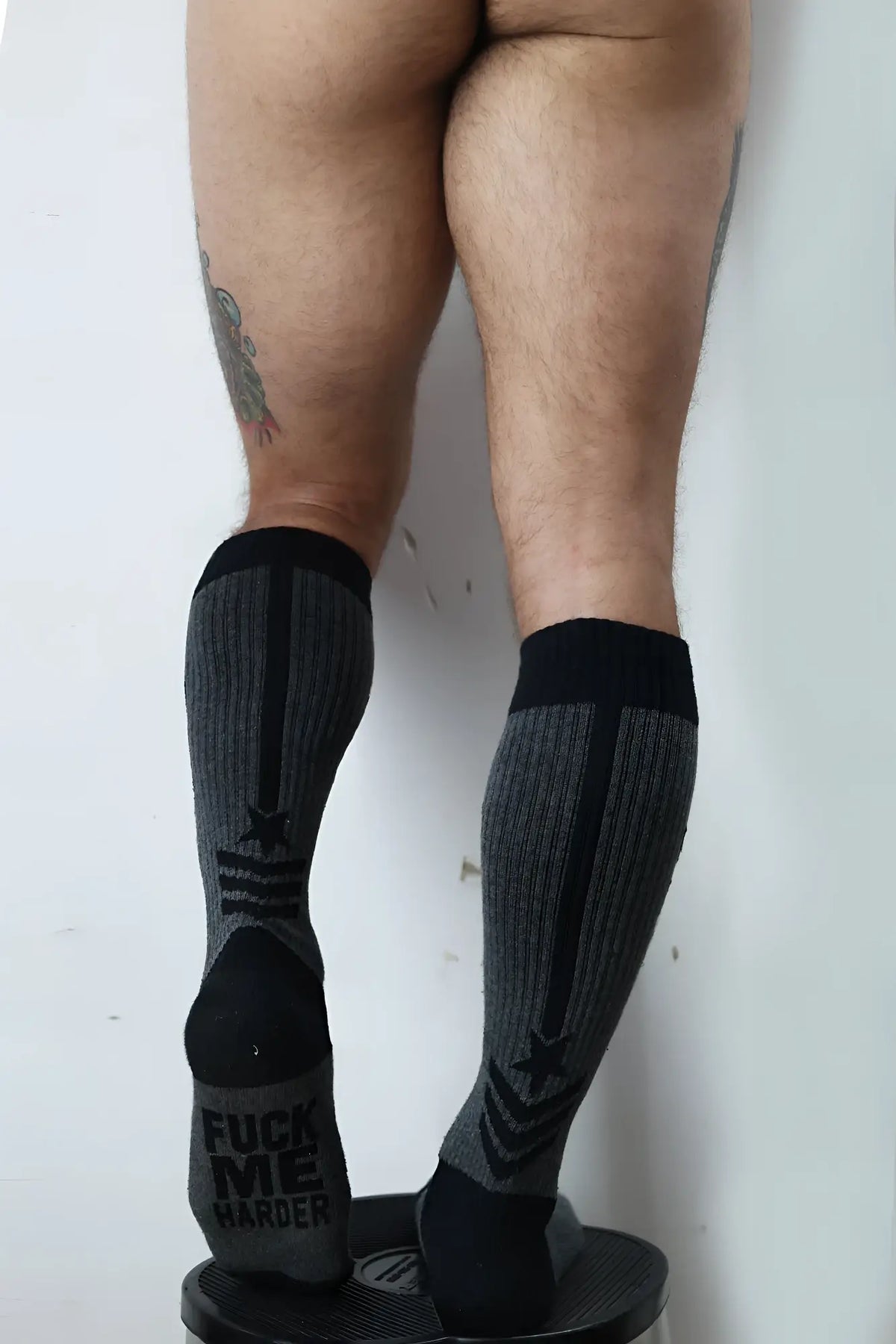 Black and gray cockpit socks with bold black star design and reinforced toe caps for athletic compression use