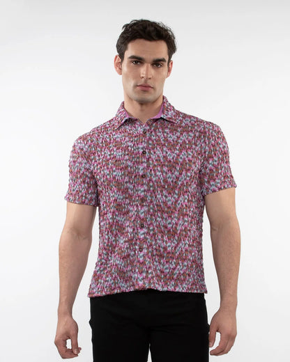 A man wearing a vibrant pink and white crinkle knit short sleeve shirt with a floral pattern