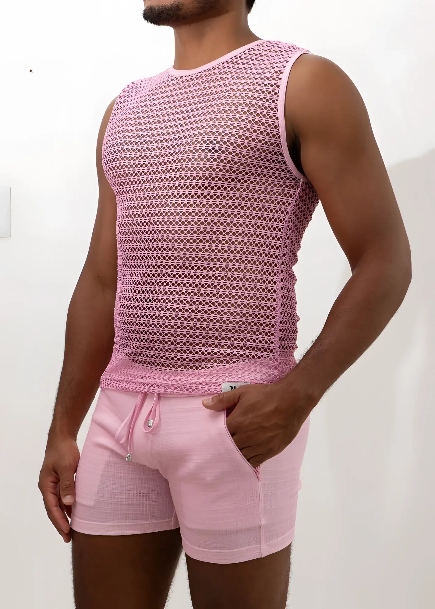 Crochet muscle tank top in pink mesh with subtle geometric pattern paired with matching pink drawstring shorts