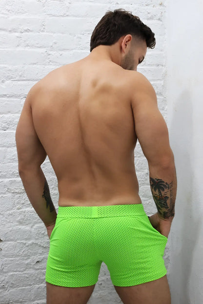 Neon green cruiser shorts made of perforated mesh fabric offering breathable comfort for active wear