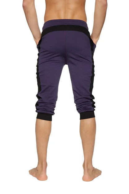 Purple cuffed yoga pants with black side panels and elastic cuffs made from athletic fabric for active wear