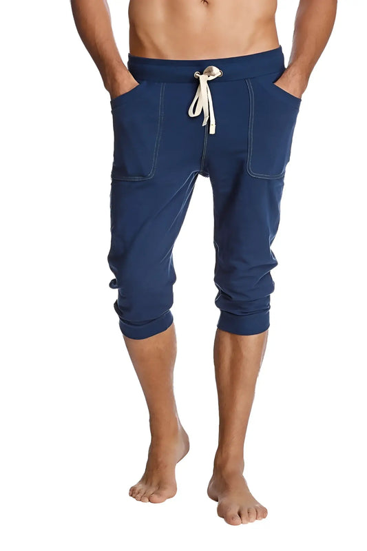 Navy blue cuffed yoga pants with capri length, white drawstring, and side pockets for comfortable workouts