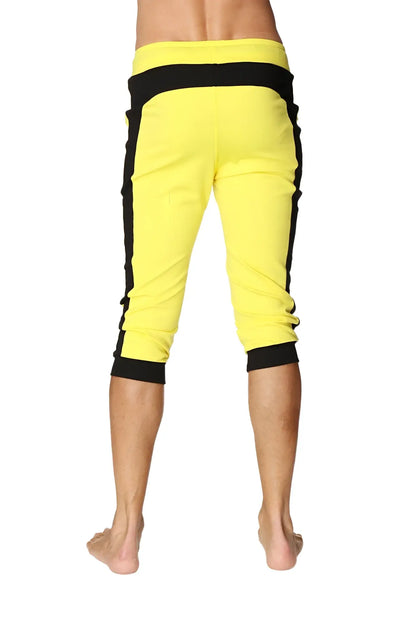 Cuffed yoga pants in tropic yellow with black side stripes featuring an elastic waistband and bright capri length
