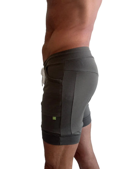 Dark gray cuffed yoga shorts with ribbed side panels and white drawstring for athletic use