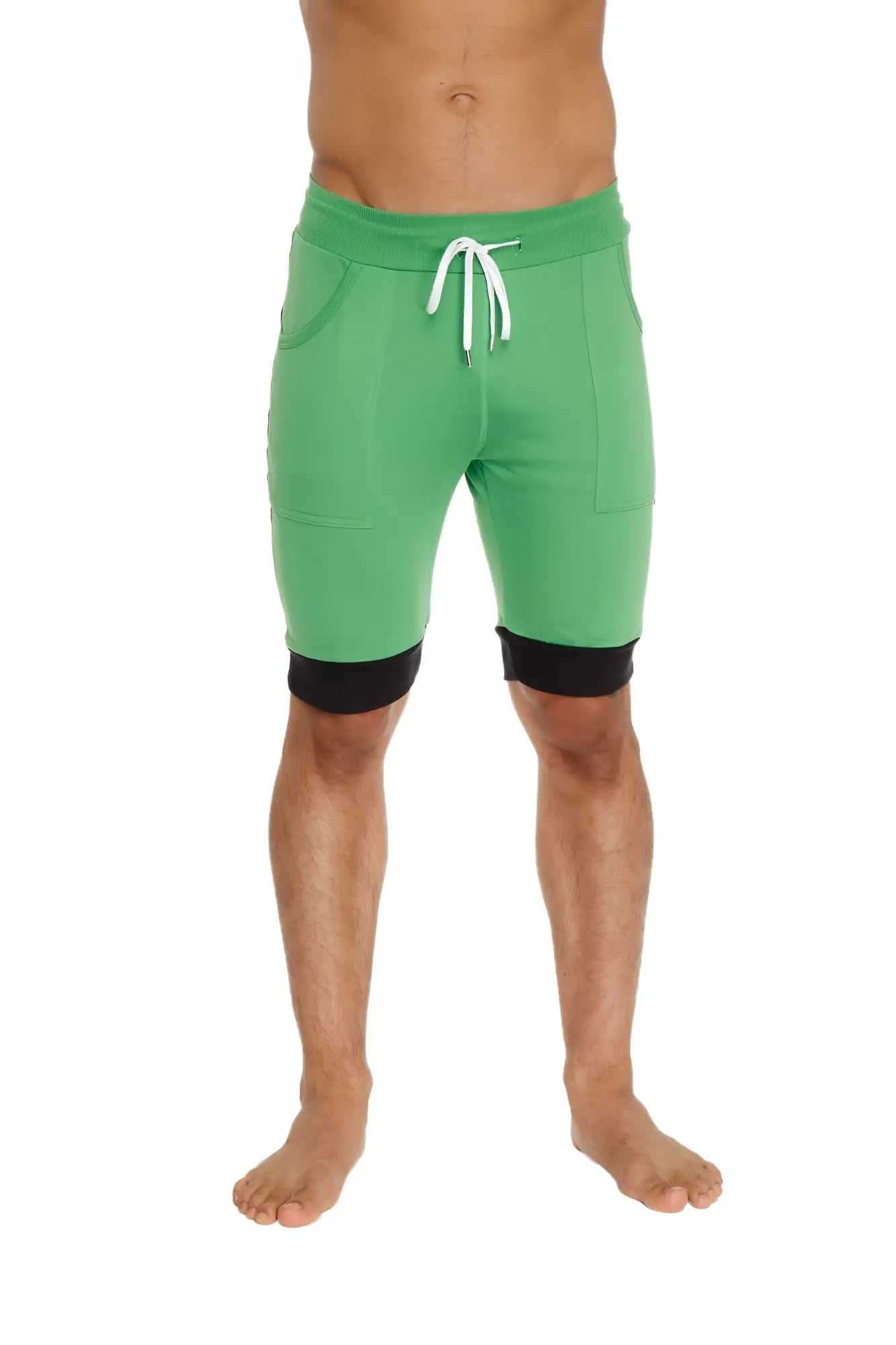 Green cuffed yoga shorts with black trim cuffs and white drawstrings designed for athletic wear