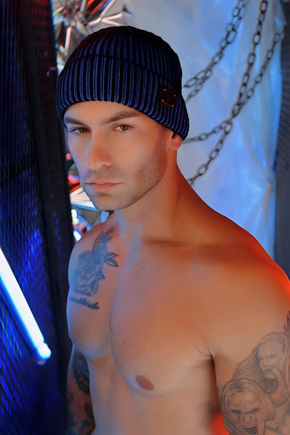Blue ribbed knit darkroom rib beanie with a small dark rectangular patch on the front for cold weather wear