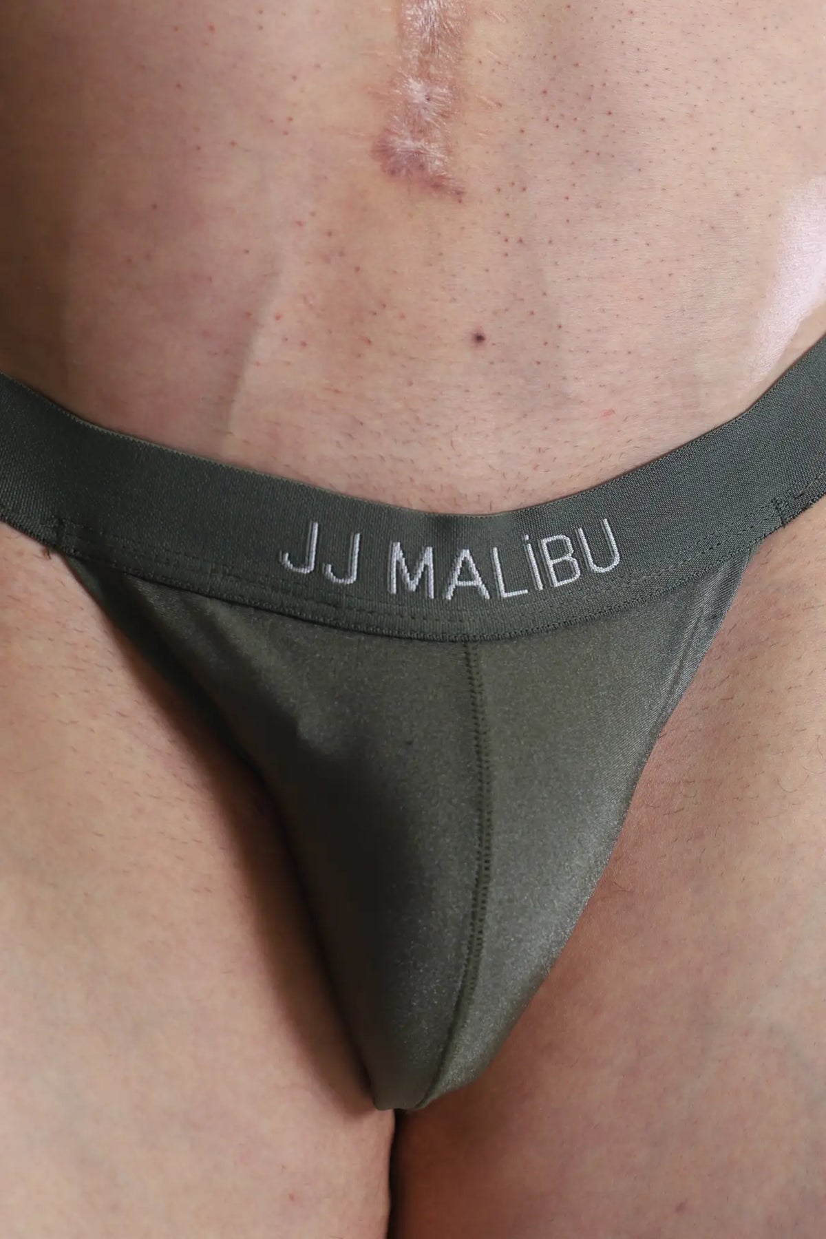 Olive green deep back V jockstrap with smooth stretchy fabric and subtle stitching shown from the back side