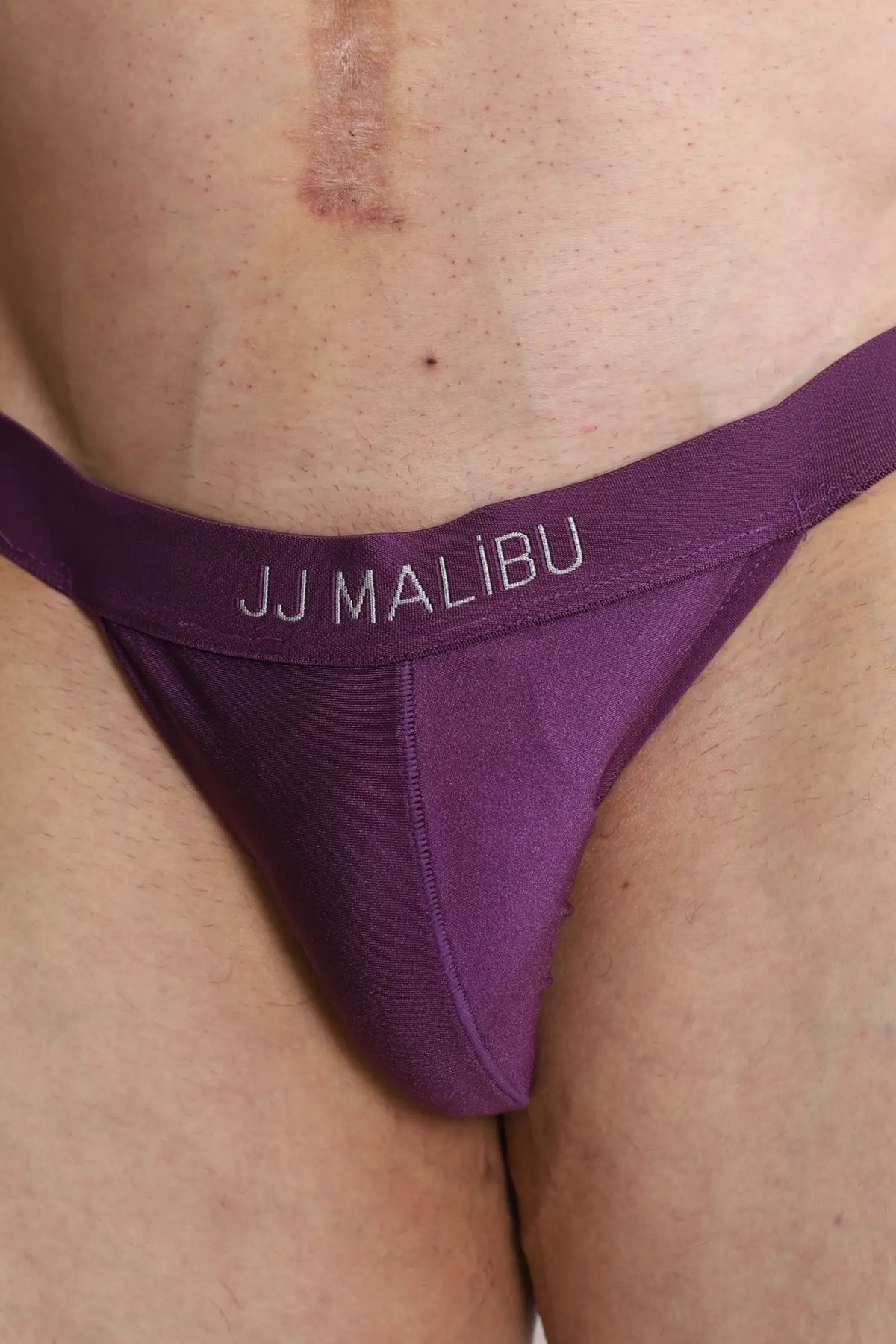 Back view of deep back v jockstrap in plum purple with smooth stretchy fabric and subtle jj malibu logo band
