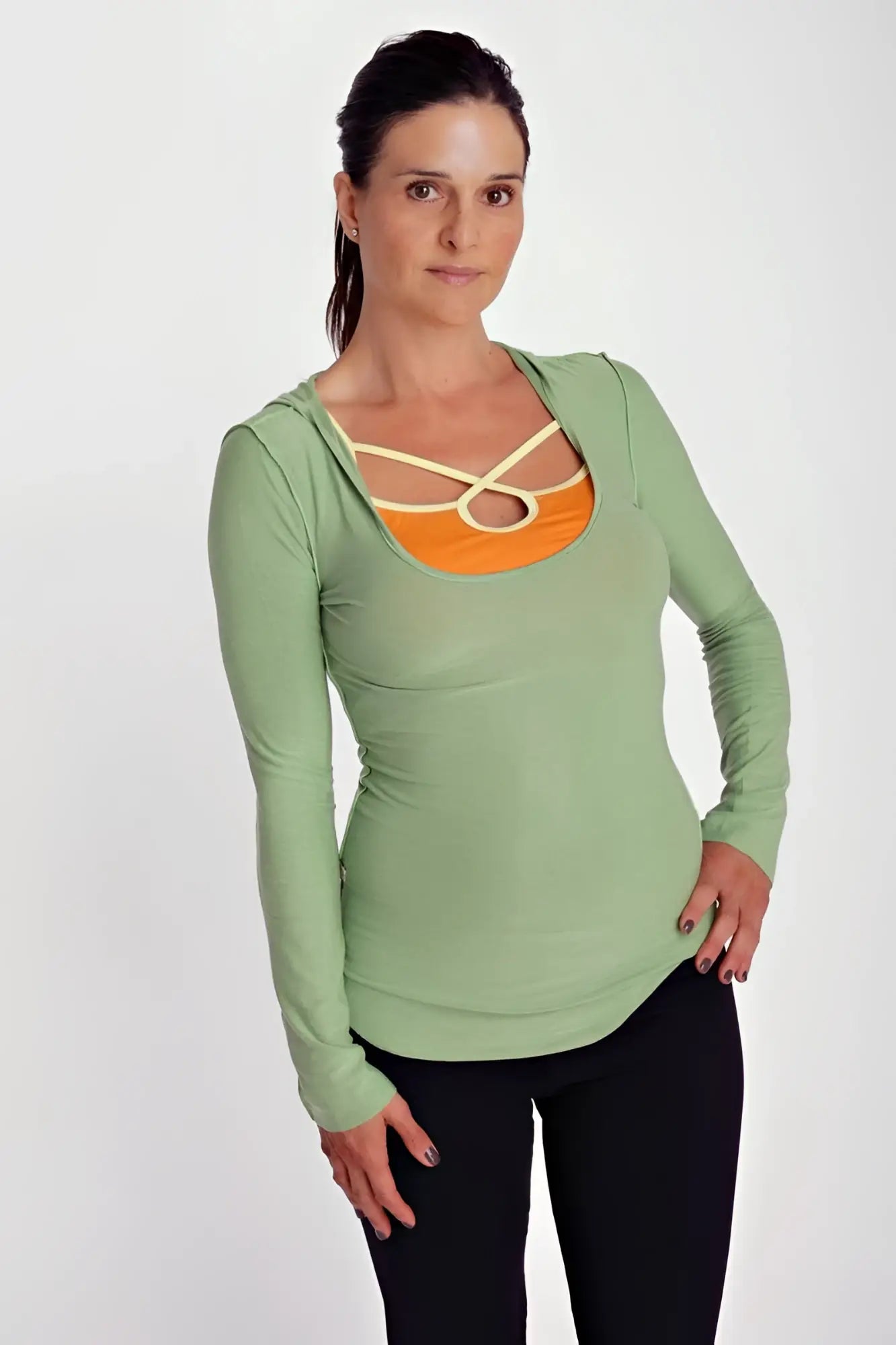 Deep scoop neck long sleeve hoodie top in bamboo green with orange panel and cream crisscross strap detailing