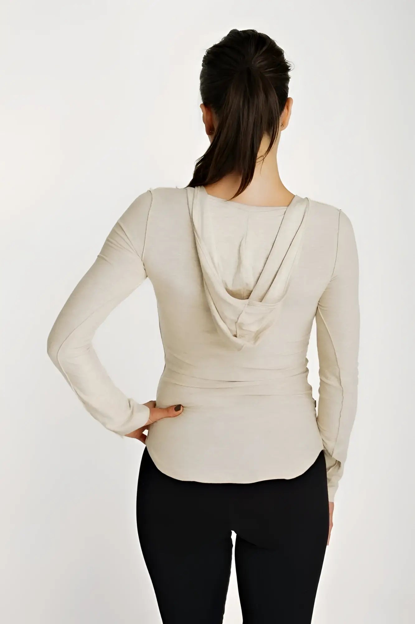 Beige long sleeve hoodie top with deep scoop neck and fitted silhouette in sand beige color