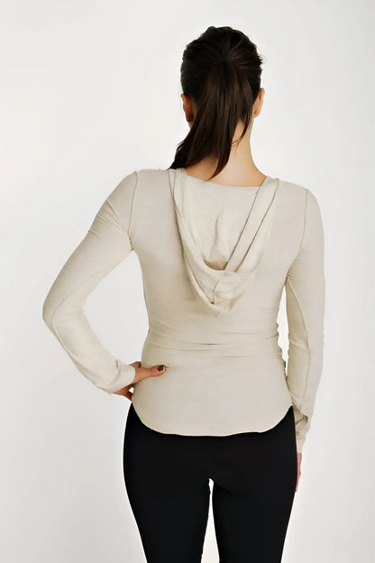 Beige long sleeve hoodie top with deep scoop neck and fitted silhouette in sand beige color