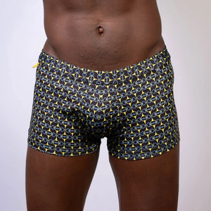 Black designer buckle print sq cut trunk swim trunks with bold yellow and light blue chain-link pattern