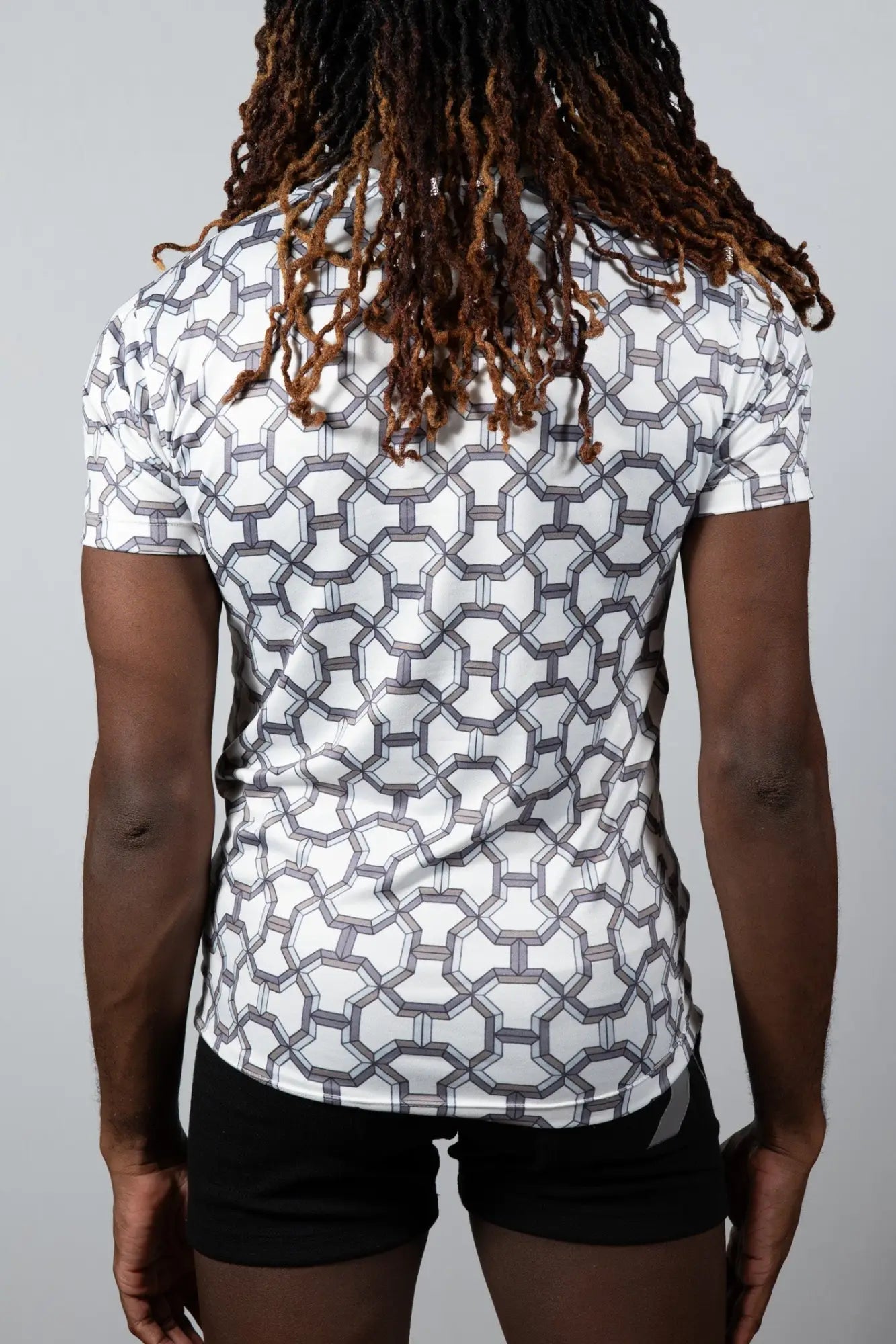White short-sleeved athletic shirt with a geometric gray pattern designed for activewear in the designer inspired print tee collection