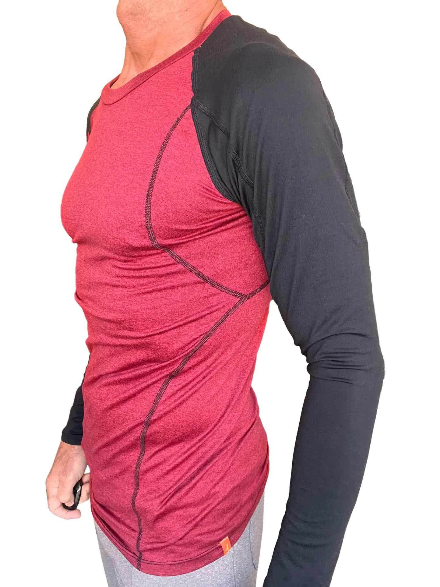A men’s long-sleeved designer raglan crew-neck tee with a red heathered body and black sleeves with stitching