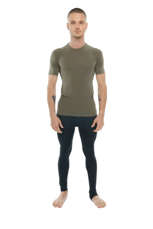 A man wearing a fitted olive green designer raglan crew-neck compression shirt with black leggings