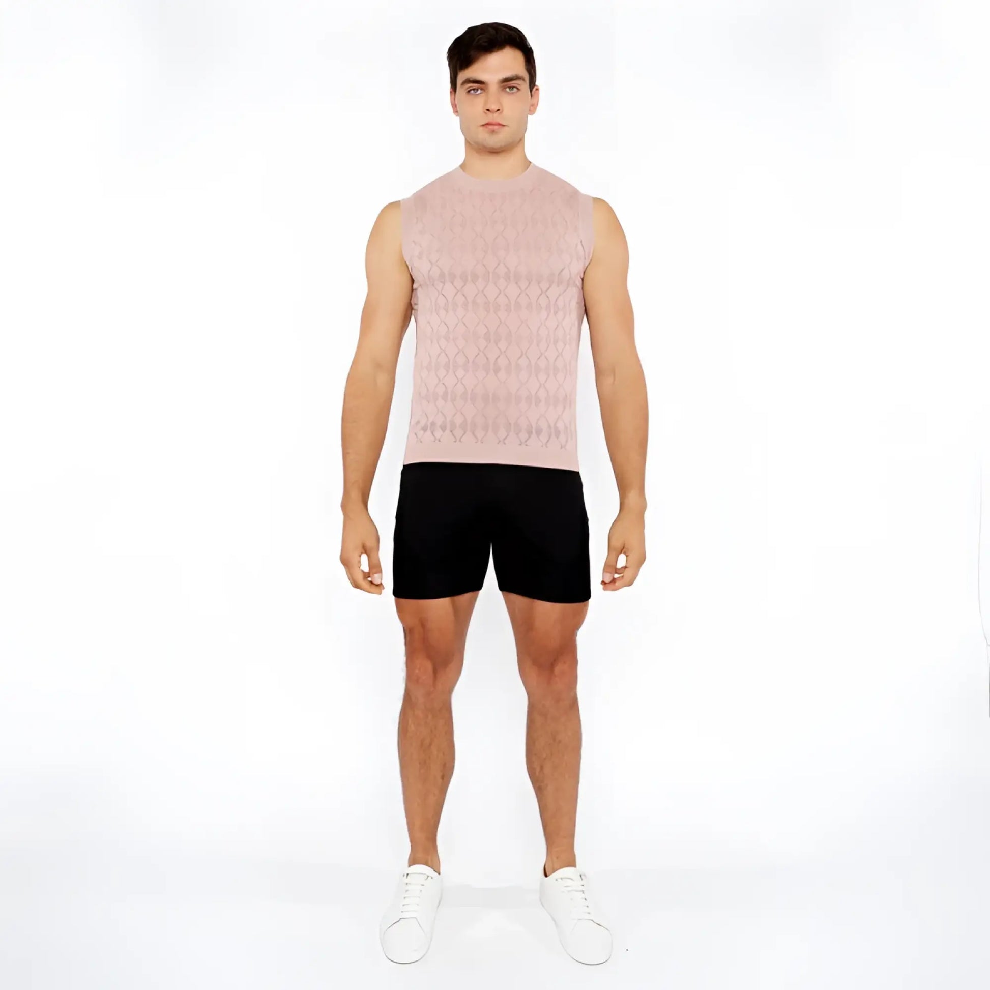 A man wearing a light pink sleeveless diamond pointelle knit vest with an intricate diamond pattern design