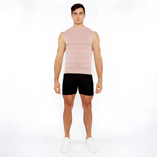 A man wearing a light pink sleeveless diamond pointelle knit vest with an intricate diamond pattern design