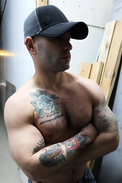 Black and gray mesh dirty trucker hat with a small embroidered logo on the front