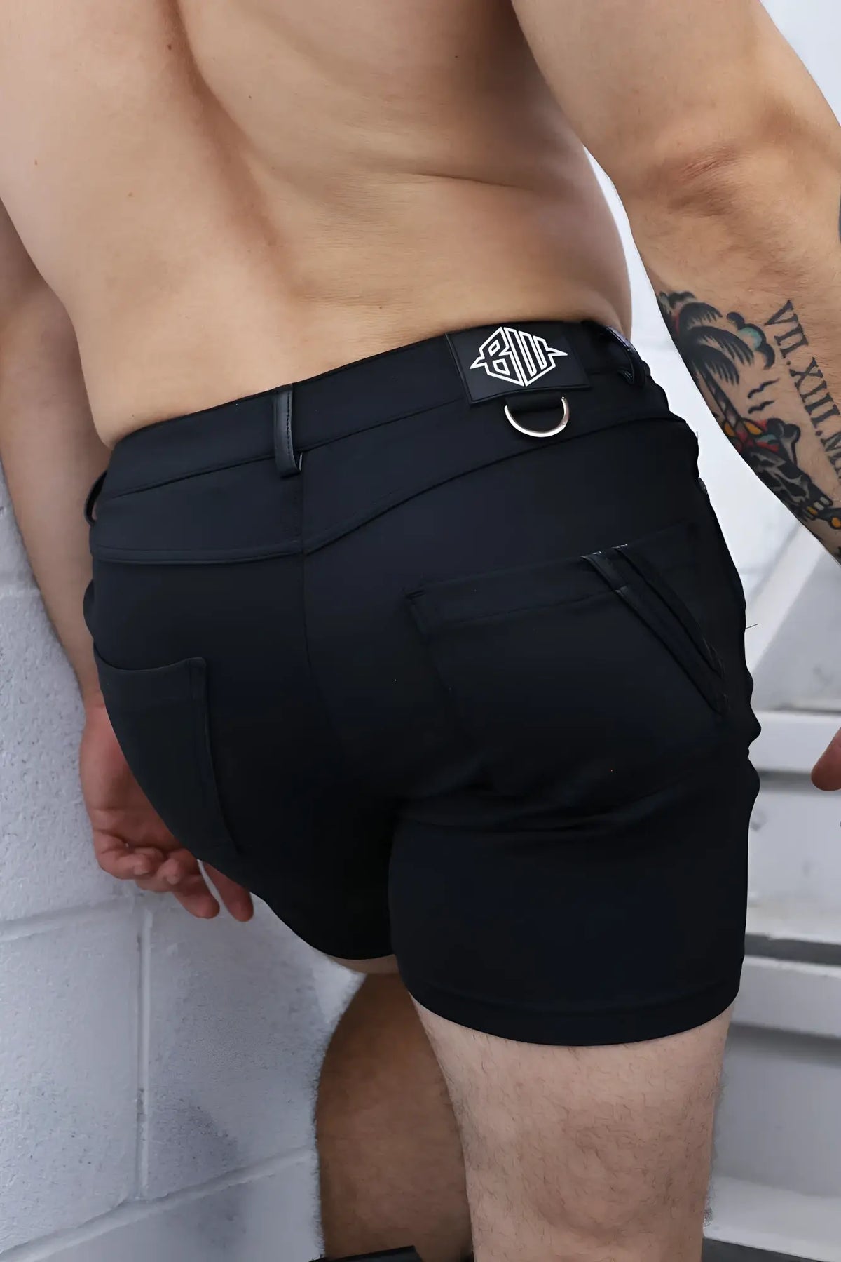 Black down low shorts featuring sleek modern design and branded patch on waistband for athletic use