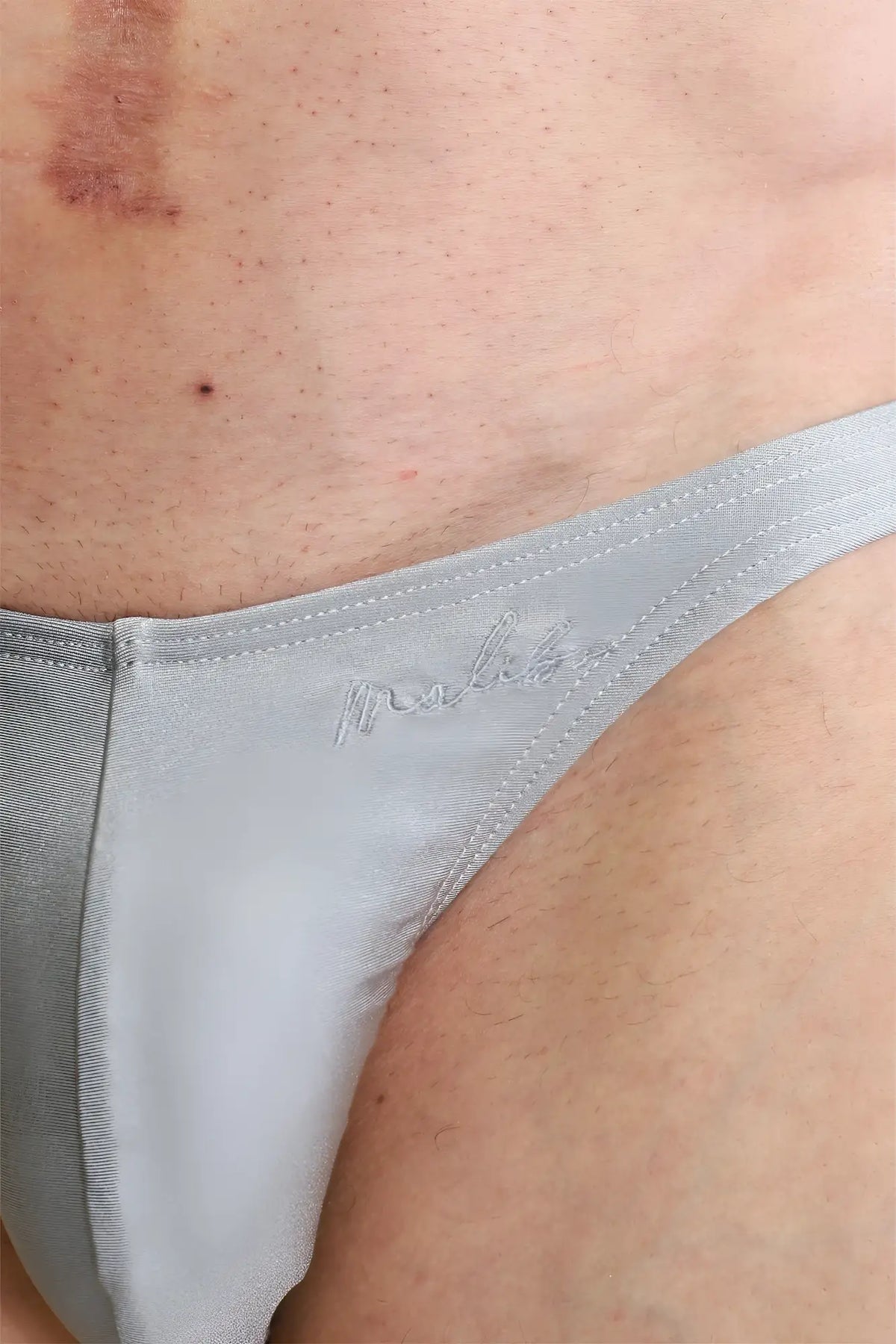 Gray satin thong with subtle embroidered logo shown from the back in dynamic classic scrunch butt brief chrome grey style