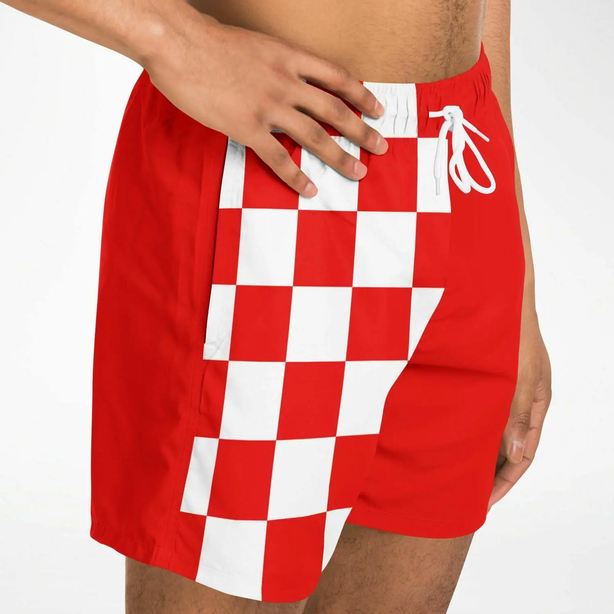 Red and white checkered men's swim shorts with an elastic waistband shown on a model by Maris Equi