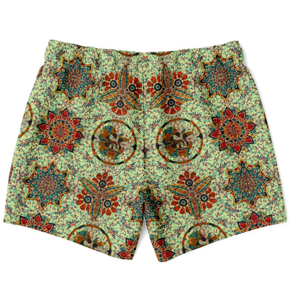 Green swim shorts with a colorful mosaic pattern featuring floral and geometric designs by Maris Equi.