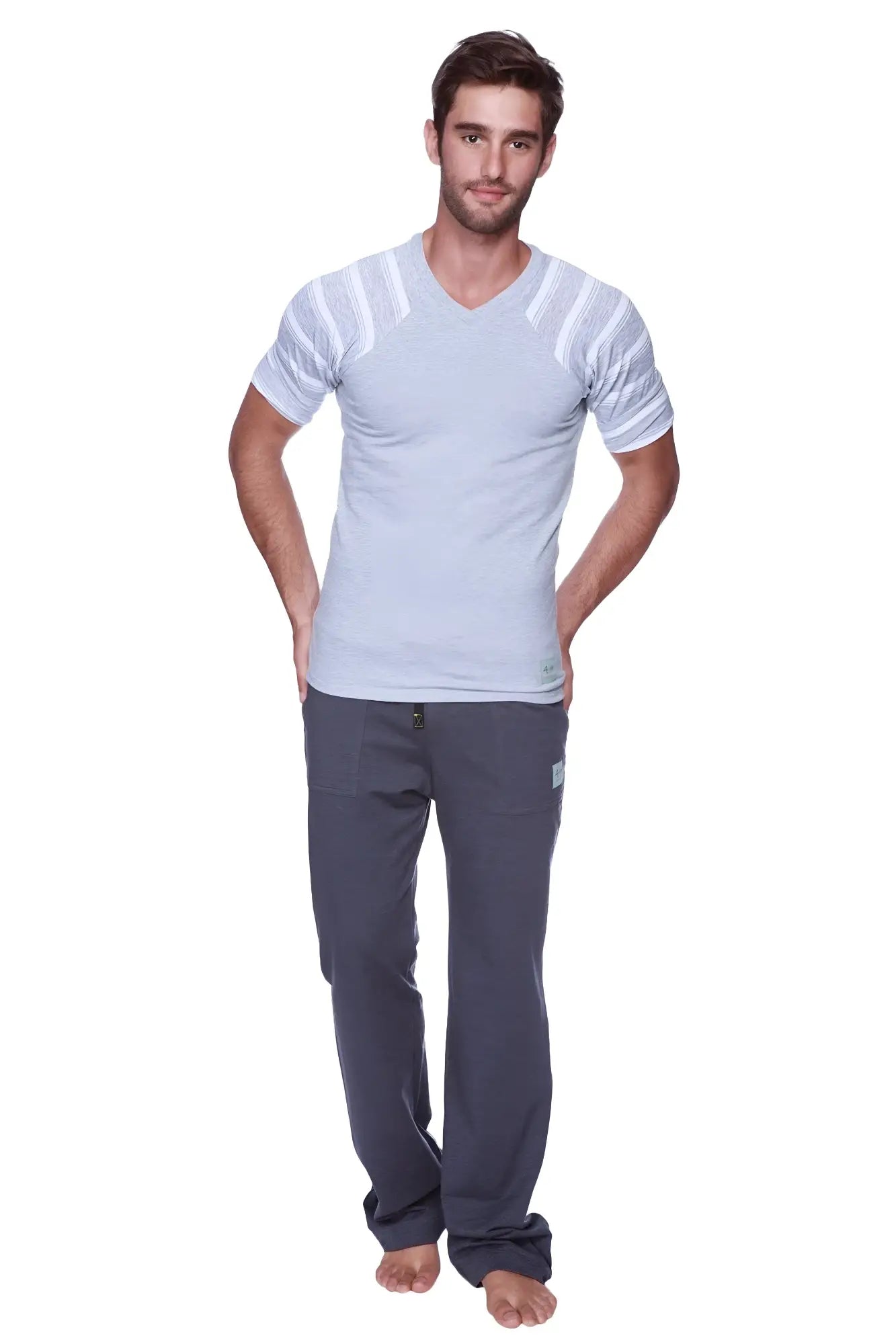 A man wearing eco-track yoga sweat pants in charcoal with royal blue paired with a light gray v-neck t-shirt