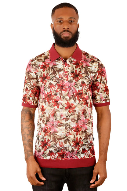 A man wearing an entwine form polo shirt with red and brown floral pattern on light beige with maroon trim