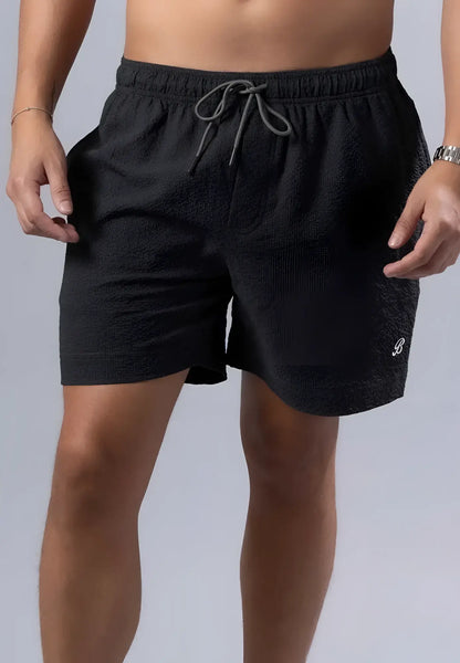 Black textured essential swim short with gray drawstring waistband and white logo on lower right leg available in 3 colors