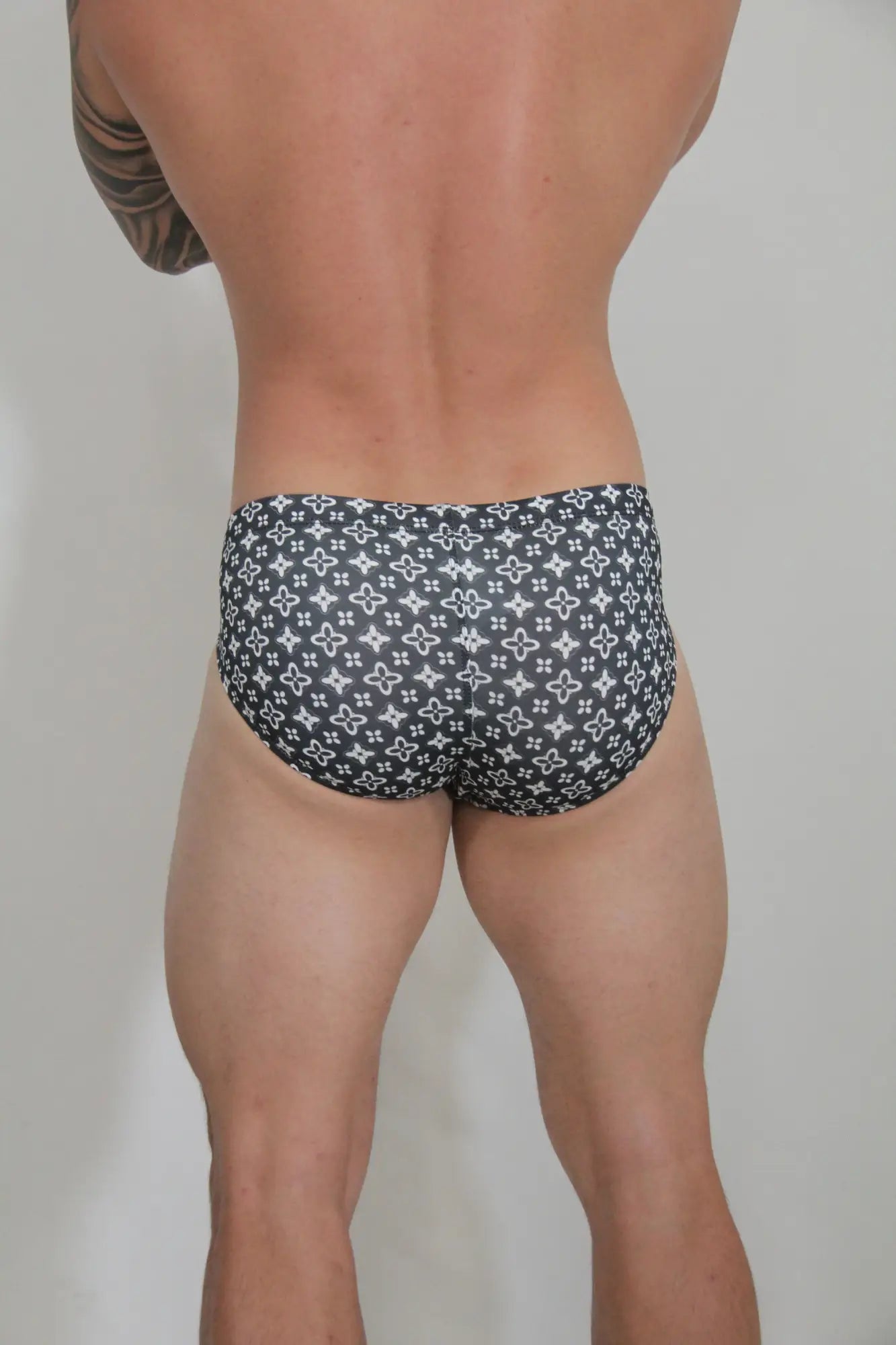Black swim brief with repeating white monogram pattern designed as fancy symbols swim brief for stylish wear