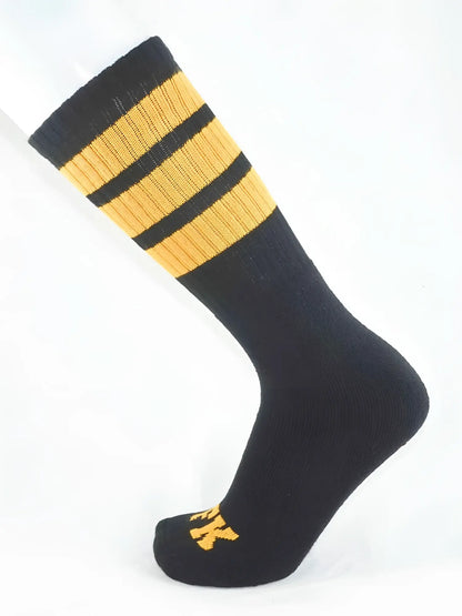 Fk sport black tube sock with three gold stripes near the top and a small gold logo on the toe made for athletic use