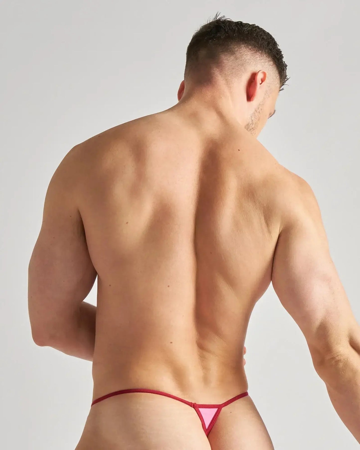 Pink triangular micro thong with red trim featuring sheer mesh fabric for a bold and flirty look