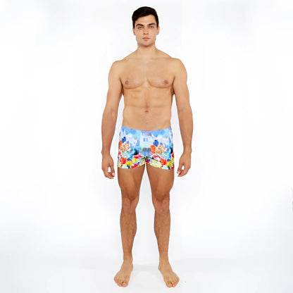 Men’s floral abstract printed swim shorts with vibrant red yellow and blue flowers on a light background