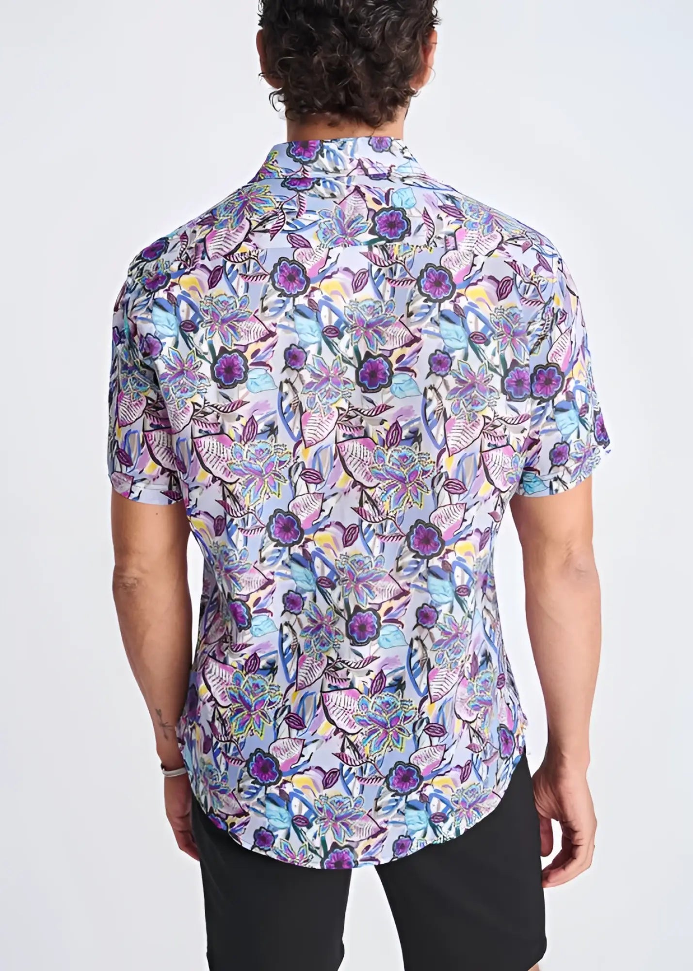 A floral lightweight linen tencel short-sleeved shirt with a vibrant purple blue and pink pattern on a light background