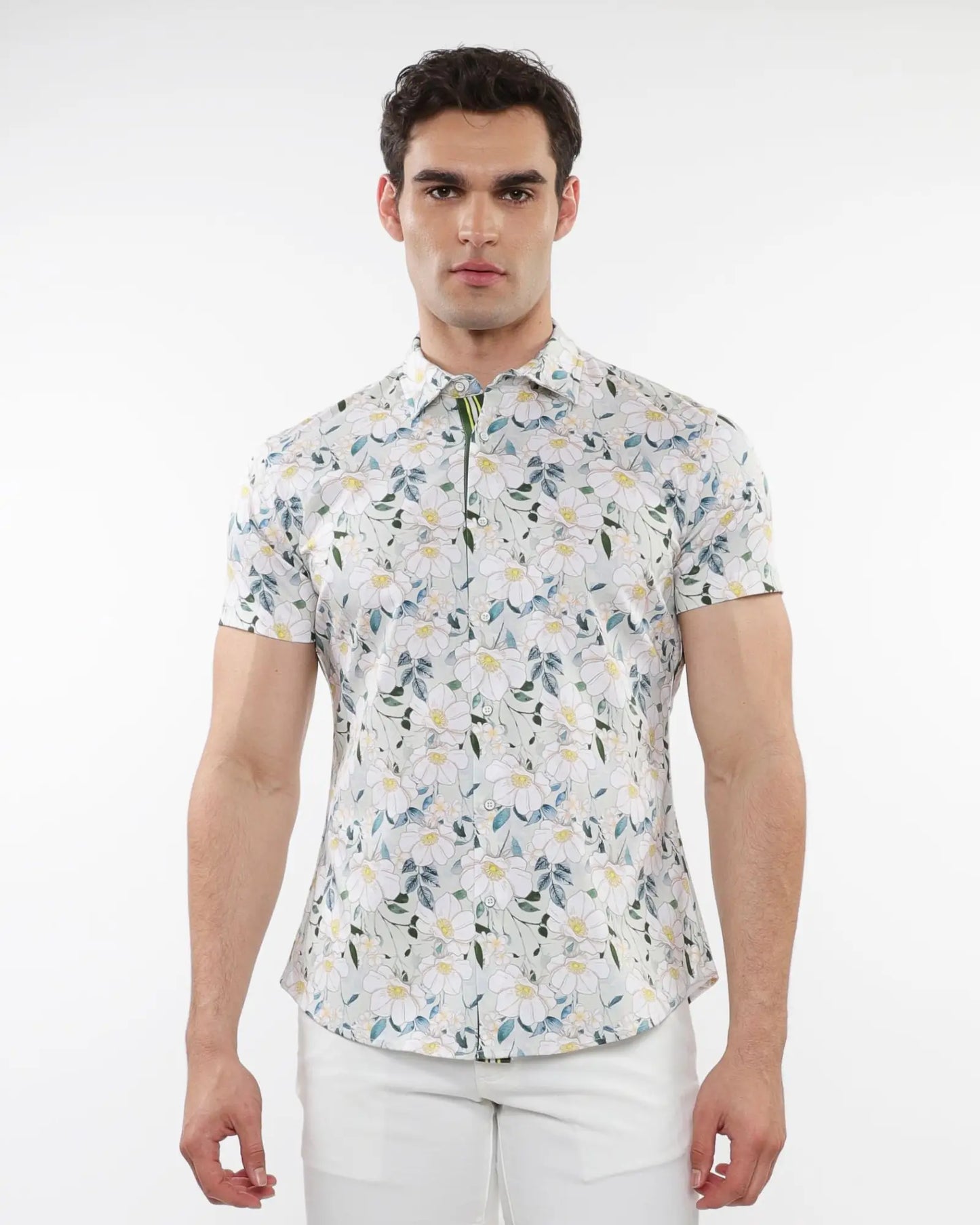 A man wearing a white floral print stretch knit short-sleeved shirt with green and yellow accents