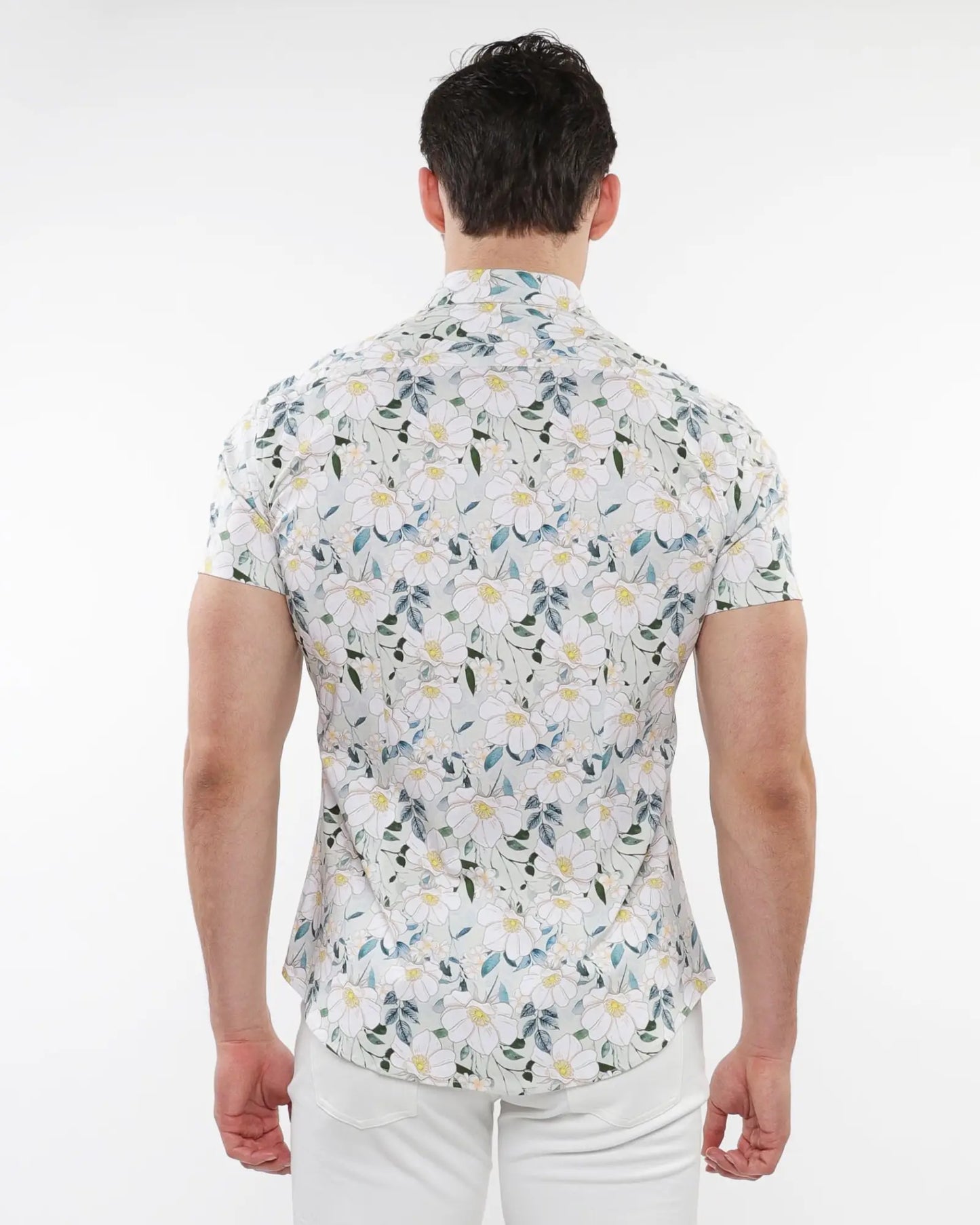 A man wearing a white floral print stretch knit short-sleeved shirt with green blue and yellow pattern