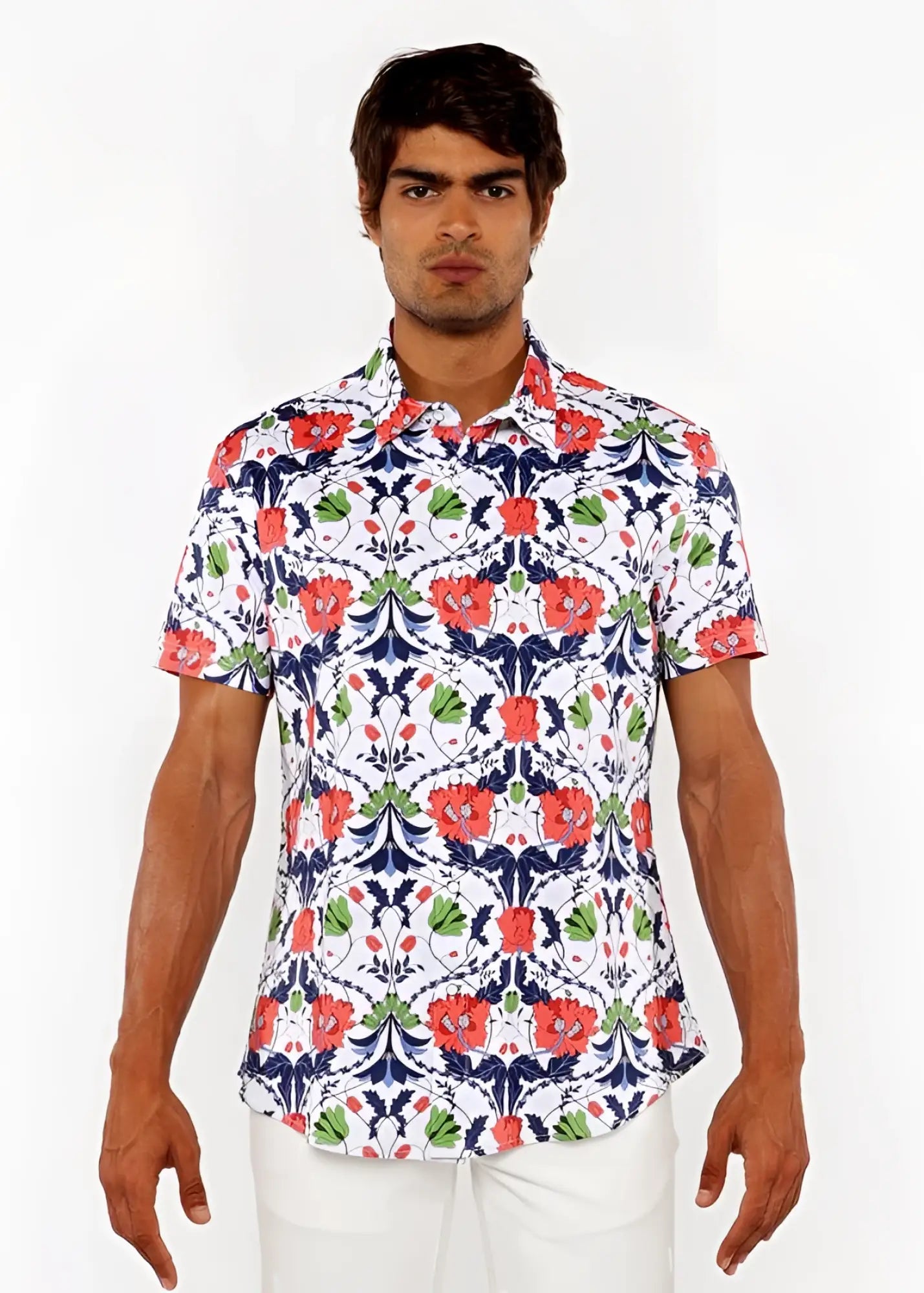 A man wearing a white floral print stretch knit shirt with red poppies green leaves and navy blue vines