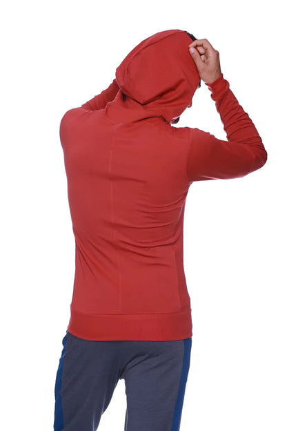 A form-fit cinnabar long-sleeved hooded sweatshirt with subtle seam detailing for yoga and track performance