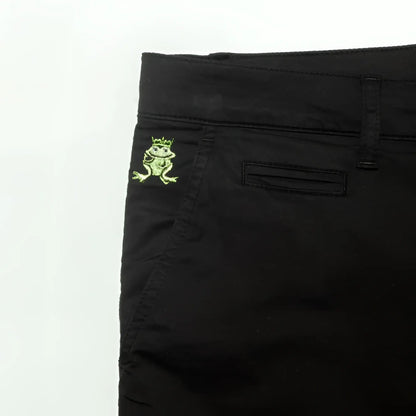 Back side of black denim frog chino short featuring an embroidered green frog with crown on the pocket