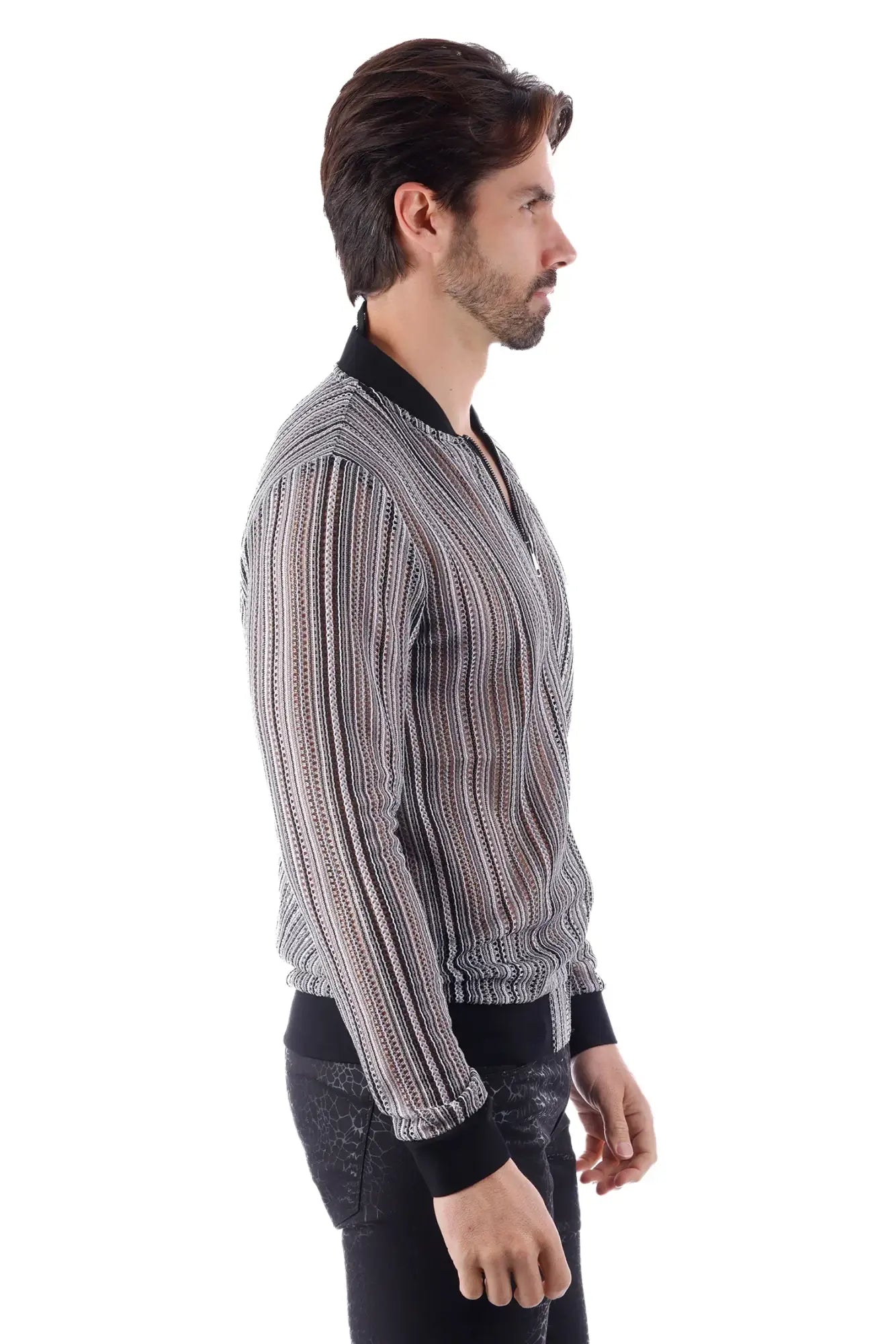 A man wearing a funky novelty bomber jacket in black and white stripes with ribbed cuffs and a lightweight fit