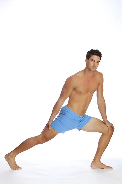 A man wearing light blue fusion yoga shorts made from breathable fabric for athletic use